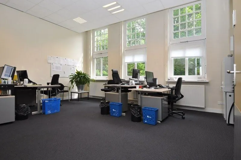 Modern kantoor met meerdere werkplekken, bureaustoelen, computers en grote ramen aan de Spechtlaan.