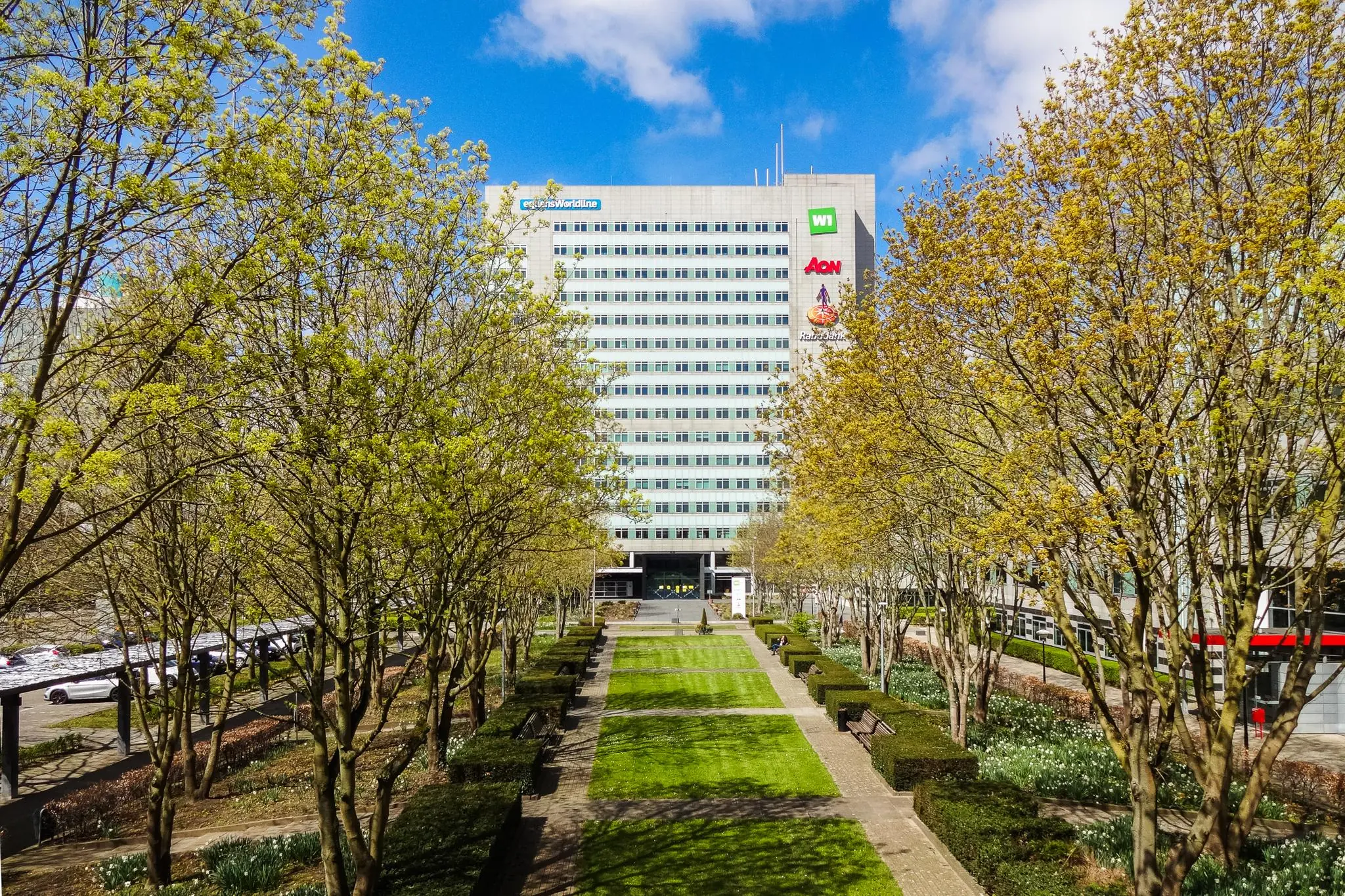 Kantoorgebouw aan de Winthontlaan in Utrecht met een groene tuin en bomen in lente-kleuren op de voorgrond.