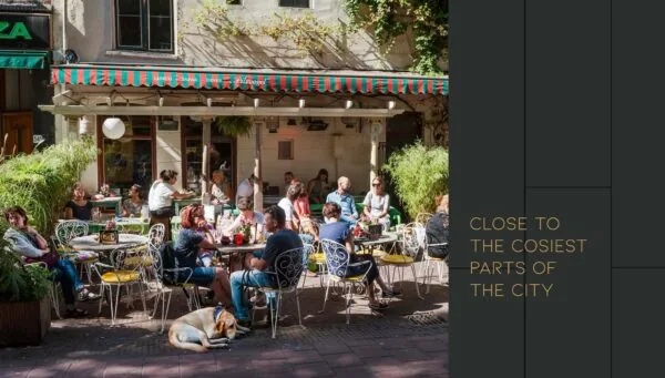 Terras vol mensen die genieten van eten en drinken bij lunchcafé Pilsvogel aan de Vijzelgracht op een zonnige dag.