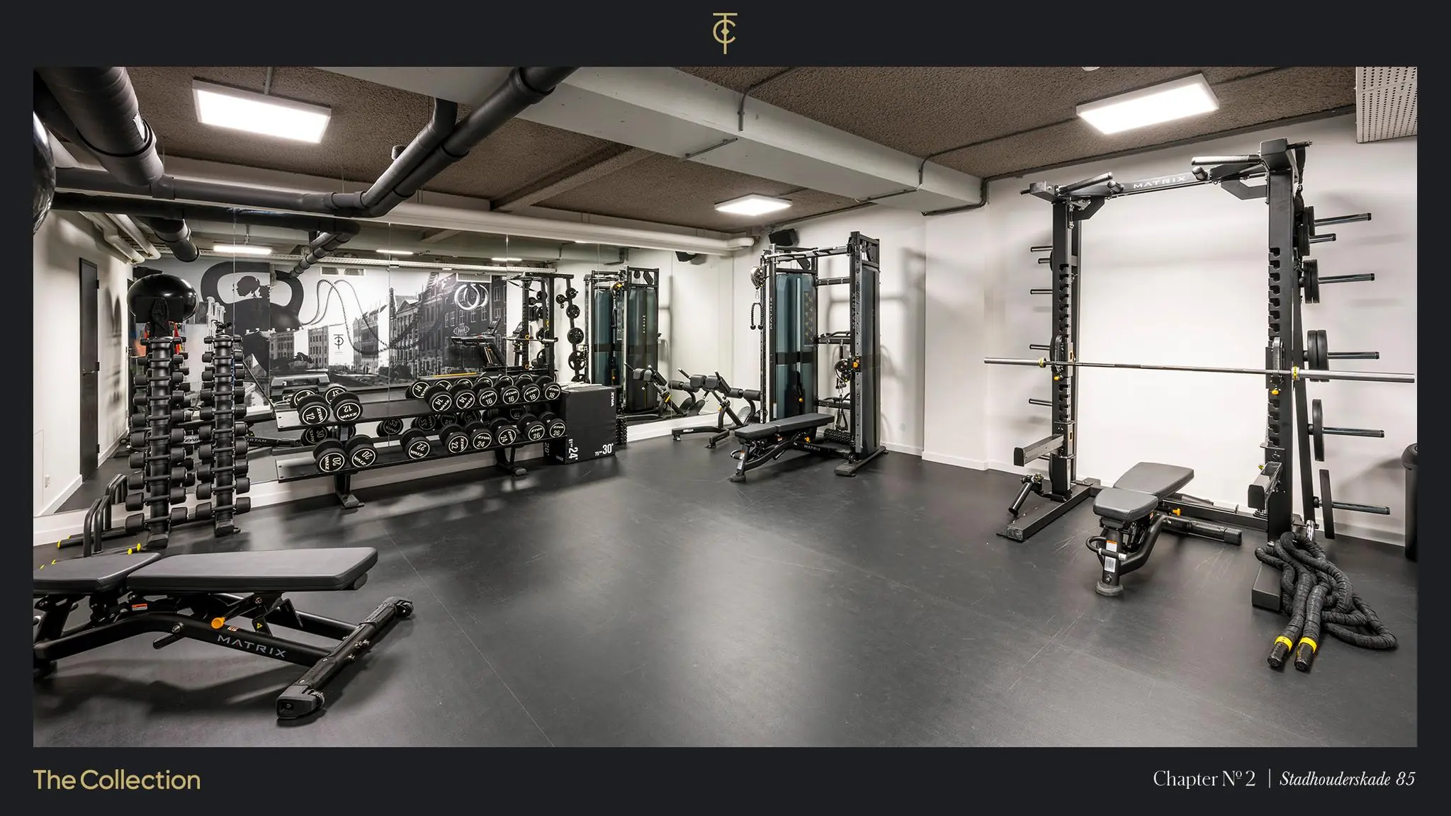 Moderne fitnessruimte in Stadhouderskade 85 met halters, krachttoestellen en trainingsbanken.