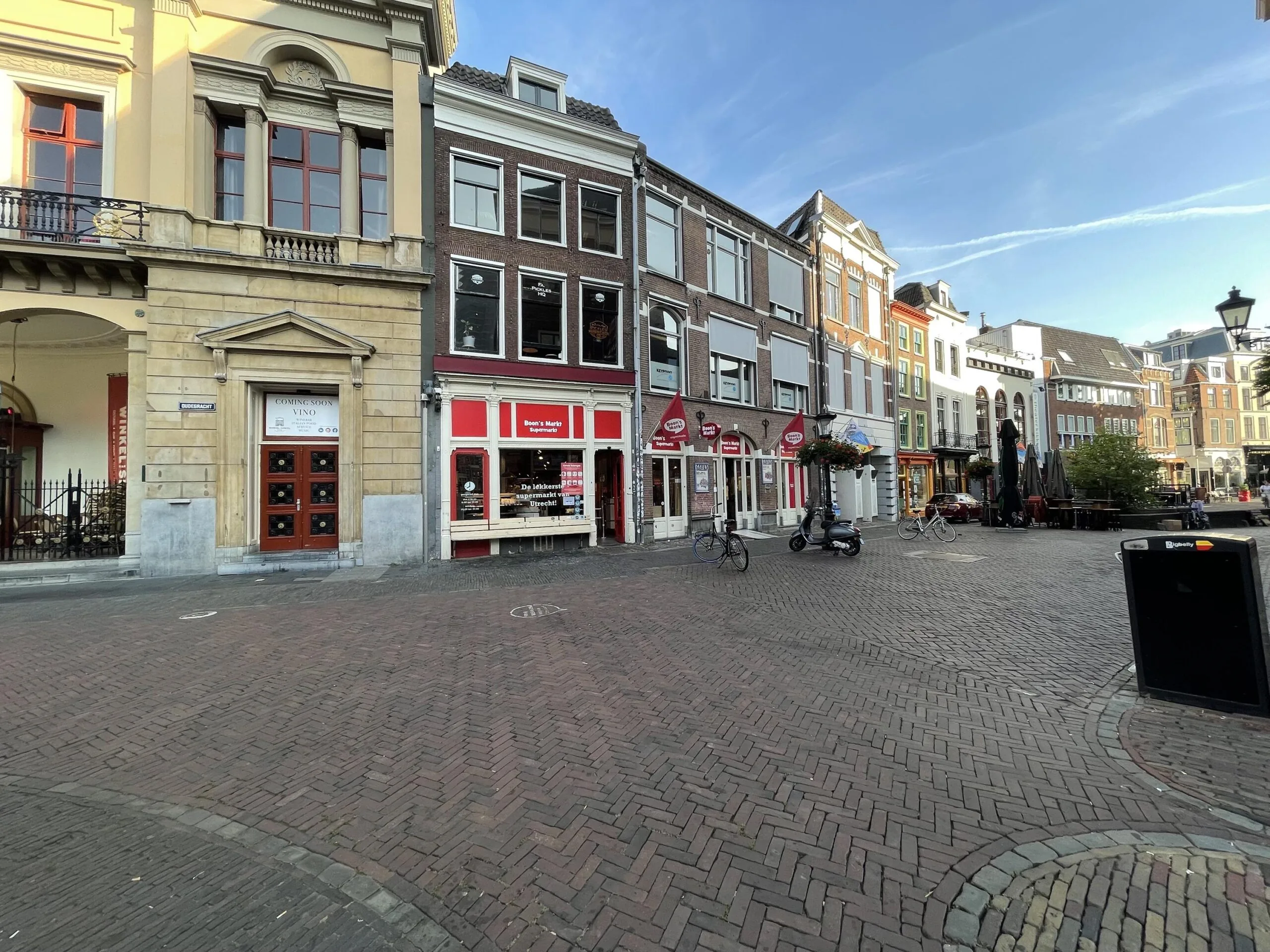Een rustige straat met historische gebouwen en winkels op de Ganzenmarkt.