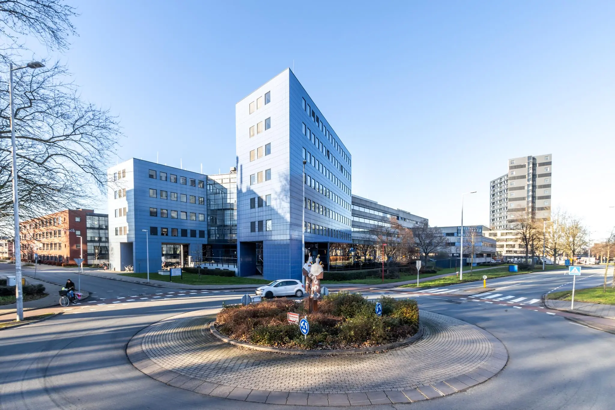 Modern kantoorgebouw aan de Oudlaan in Rotterdam met rotonde en sculptuur op de voorgrond.