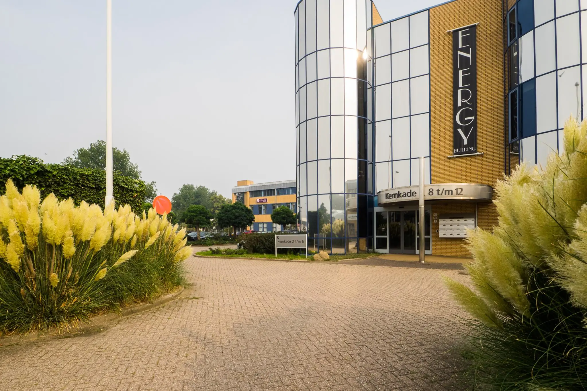 Zakelijk kantoorgebouw met spiegelende ramen aan de Kernkade, met de naam 'Energy Building' op de gevel.