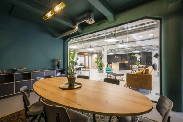Moderne vergaderruimte aan de Van Diemenstraat met uitzicht op een open kantoor en loungegedeelte.