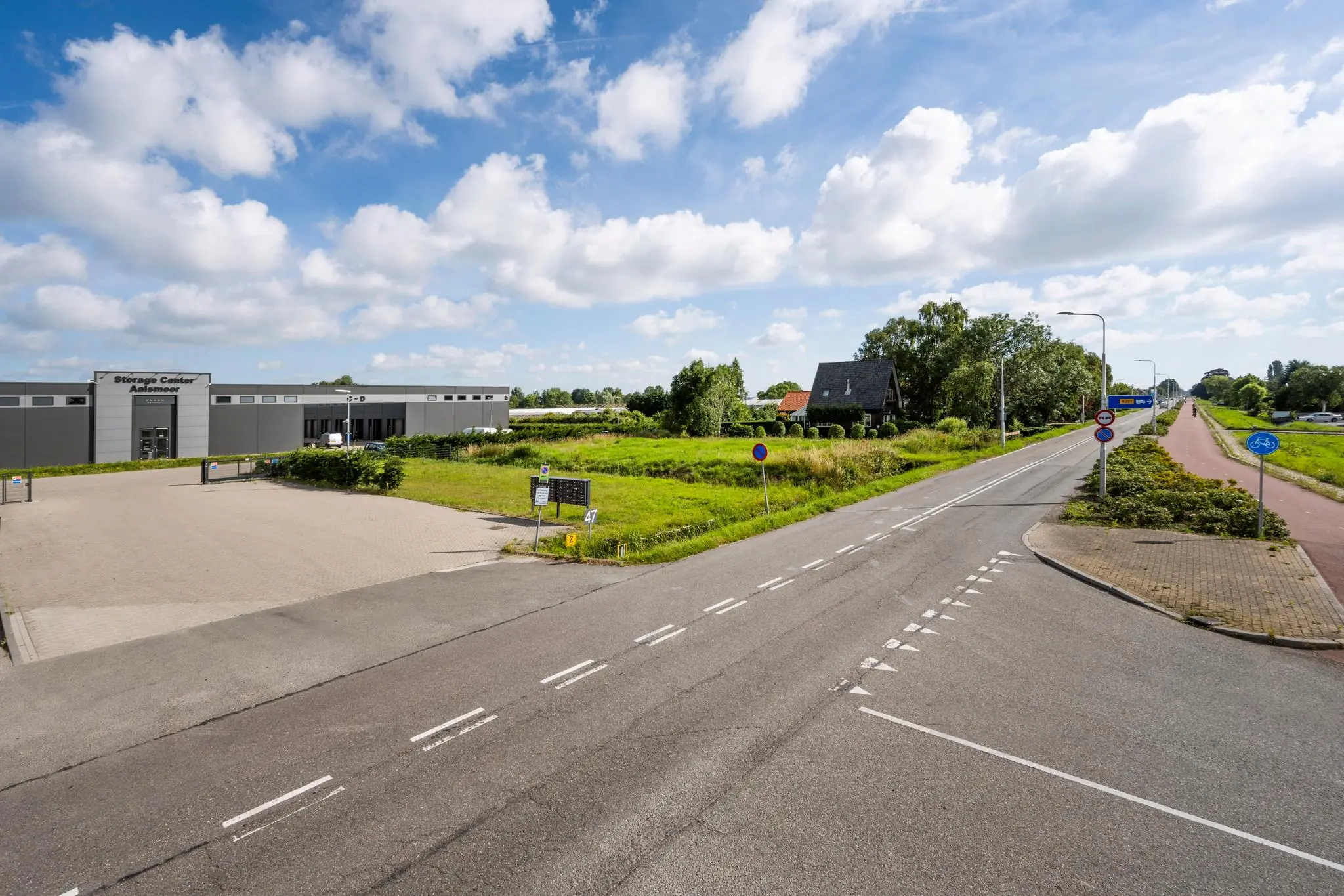 Kruispunt bij de Aalsmeerderweg met zicht op het Storage Center Aalsmeer en omliggende groene omgeving.