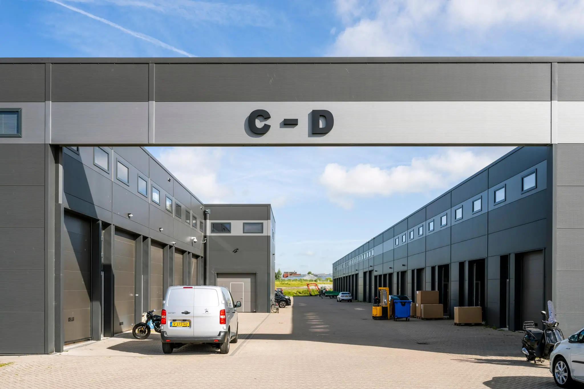 Moderne bedrijfsunits aan de Aalsmeerderweg met parkeergelegenheid en duidelijke sectieaanduiding C-D.