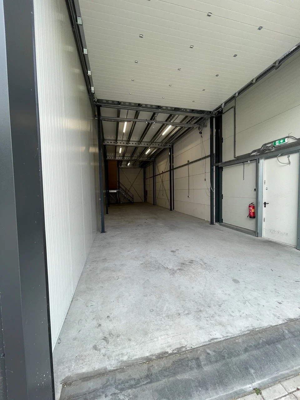Lege bedrijfsruimte aan de Aalsmeerderweg met betonnen vloer en metalen constructie.