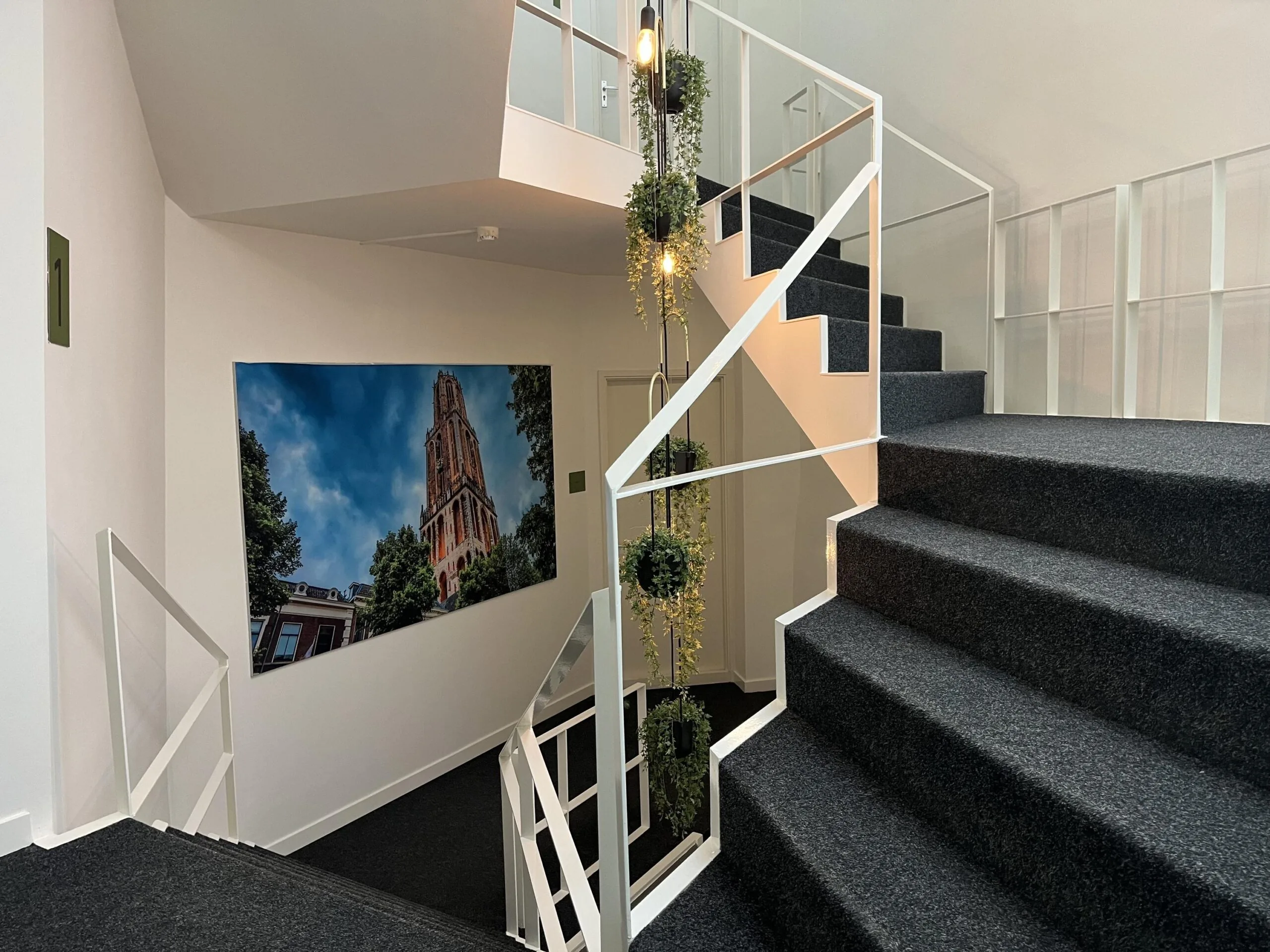 Een moderne trap met een grote foto van de Domtoren aan de muur.