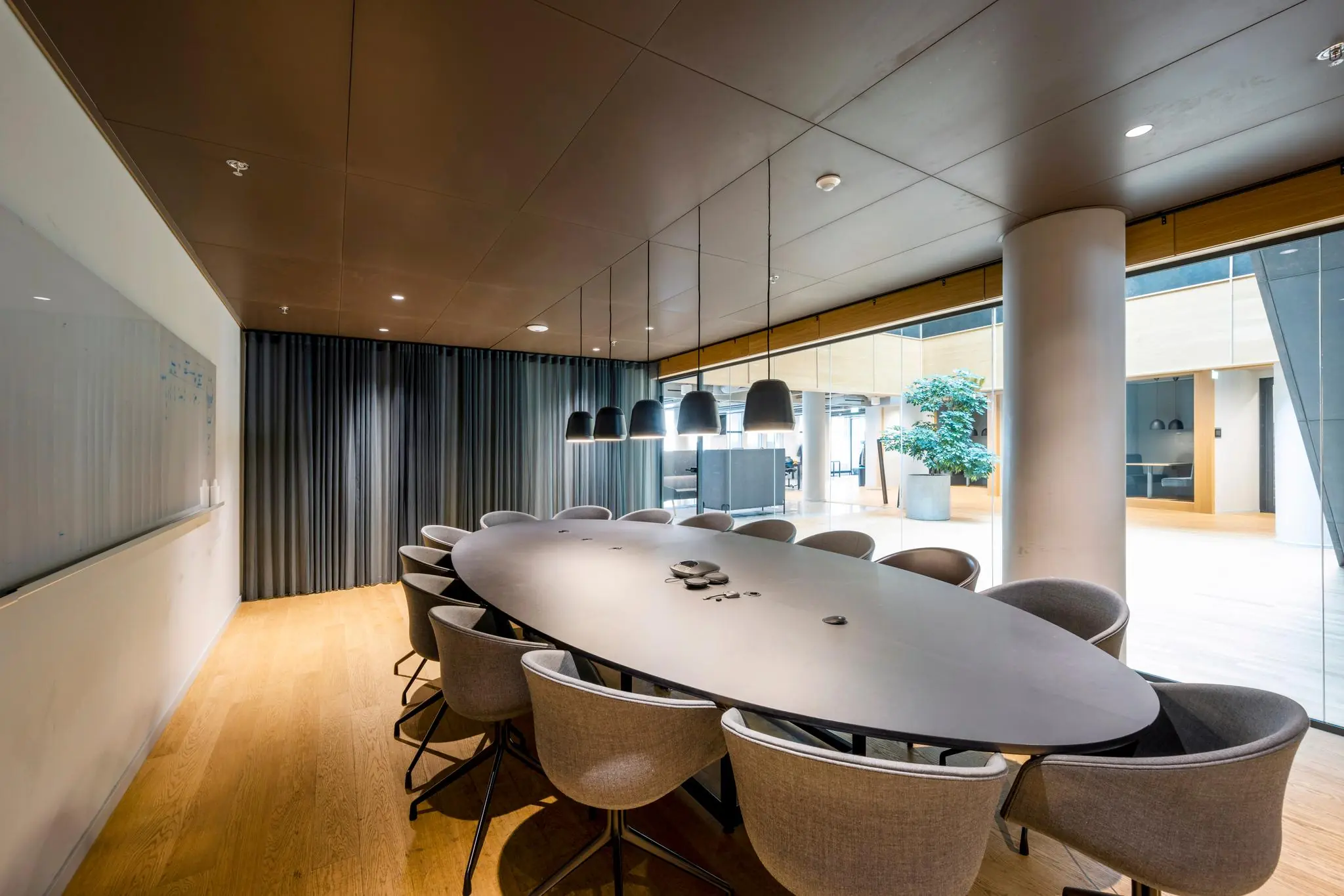 Vergaderruimte met ovale tafel, moderne stoelen en hanglampen in een kantoor aan het Rokin.
