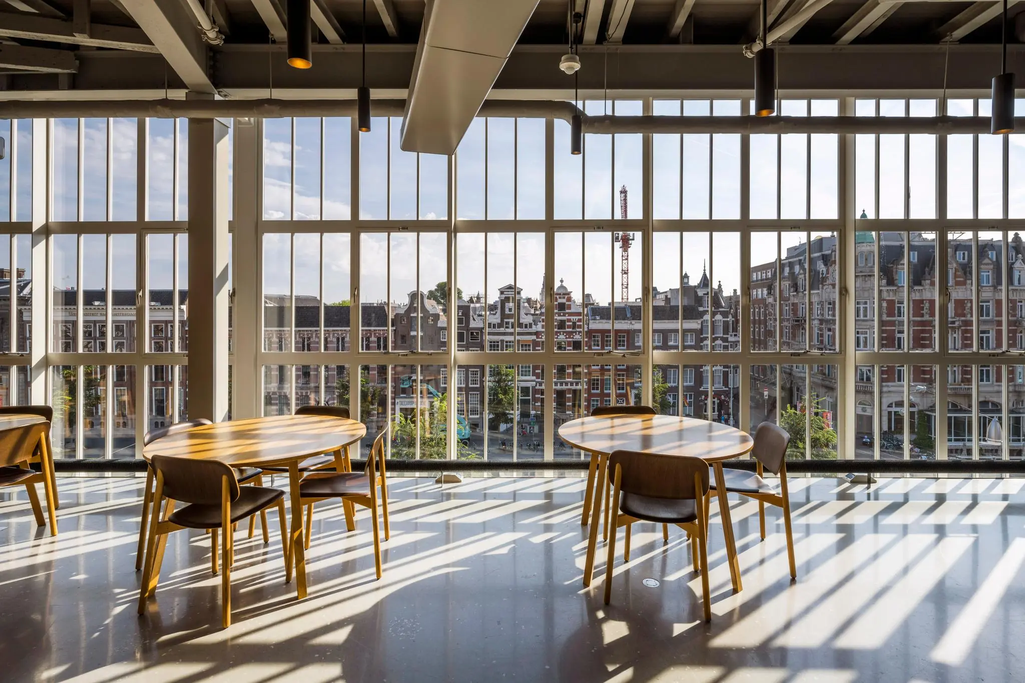 Zitgelegenheid bij grote ramen met uitzicht op het Rokin en historische gevels in Amsterdam.