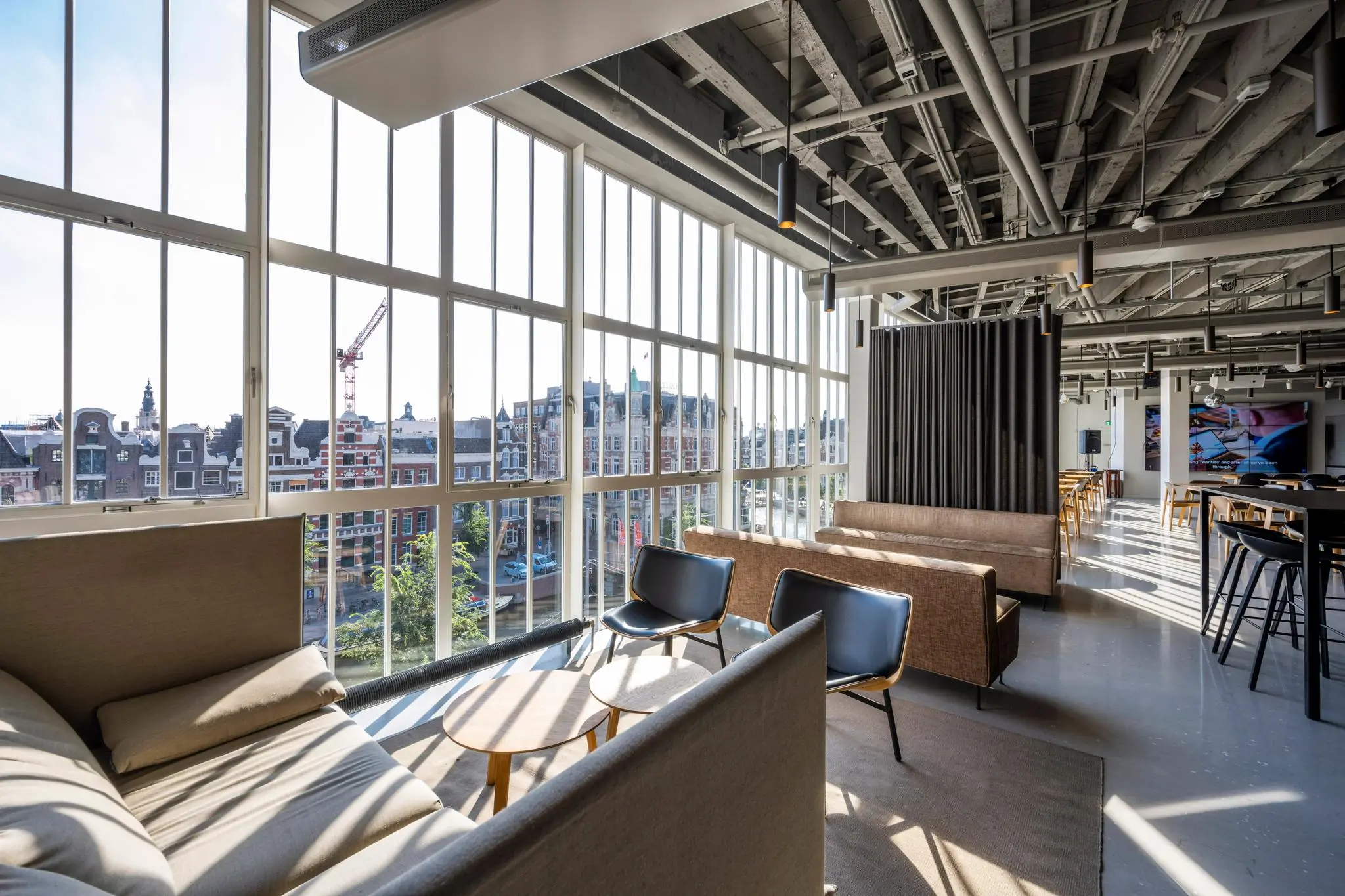 Modern kantoorinterieur aan het Rokin in Amsterdam met grote ramen en uitzicht op historische gevels.