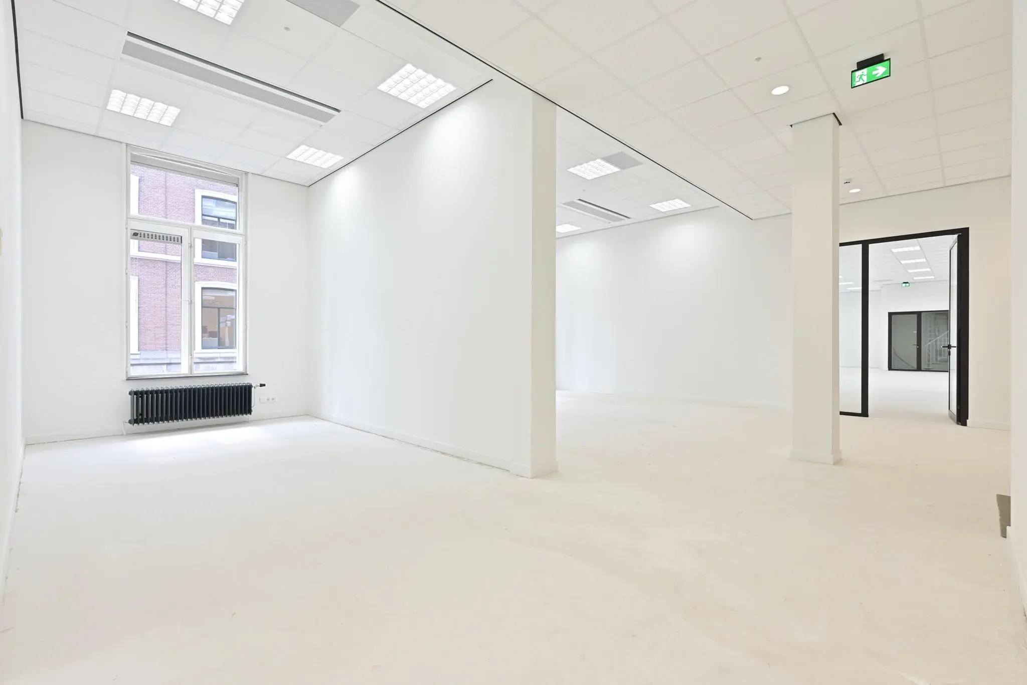 Licht en modern kantoorpand aan de Parkstraat met witte muren, systeemplafond en grote ramen.