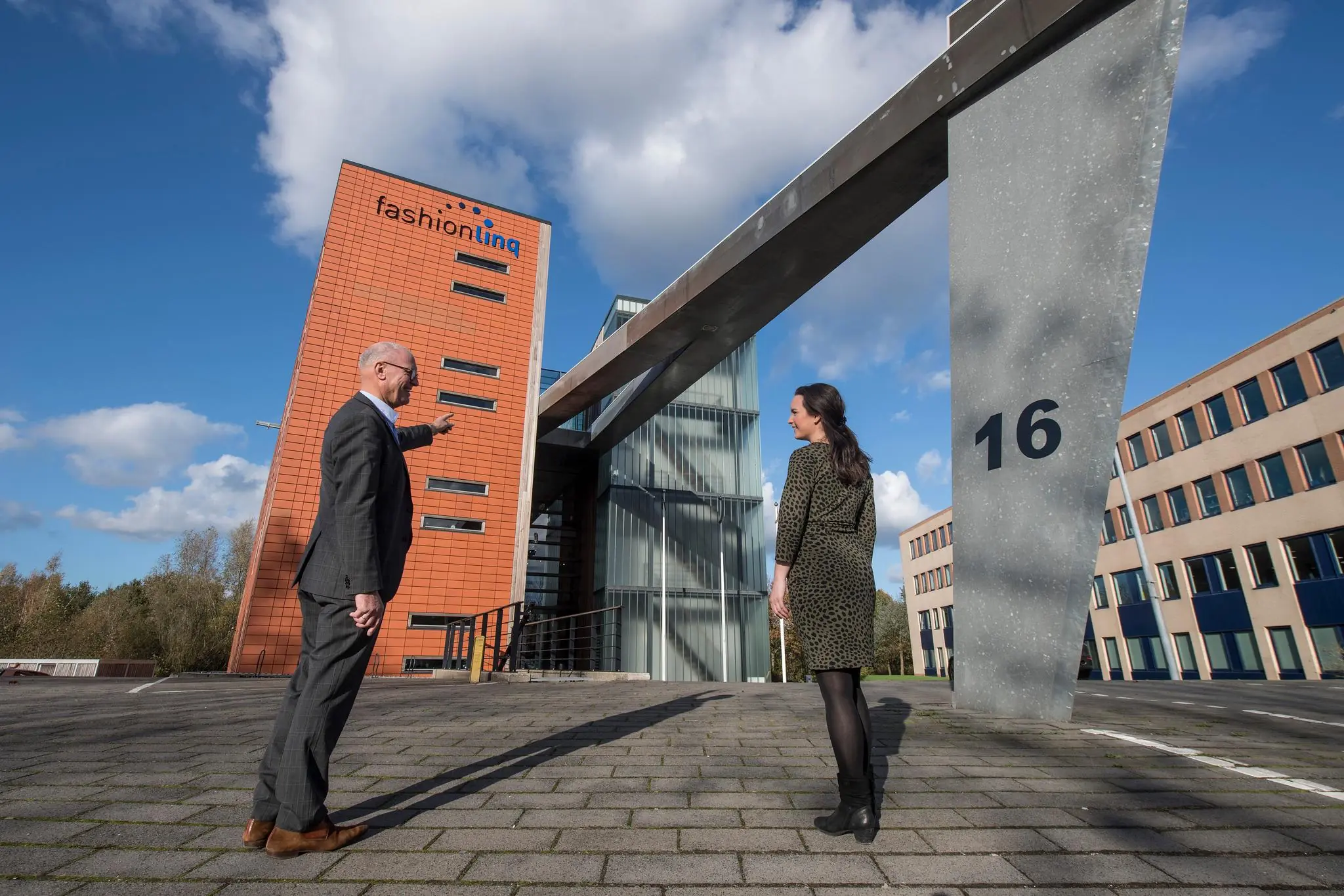 Twee personen staan voor het kantoorgebouw van Fashionlinq aan de Fokkerstraat 16.