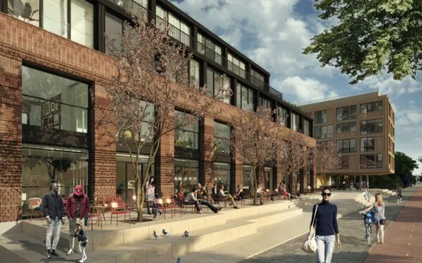 Moderne bakstenen appartementen aan de Papaverweg met terrassen, bloeiende bomen en mensen op straat.