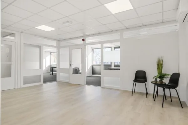 Moderne, lichte kantoorruimte aan de Nijverheidsweg met glazen tussenwanden, wachtruimte en bureaus in aparte kamers.