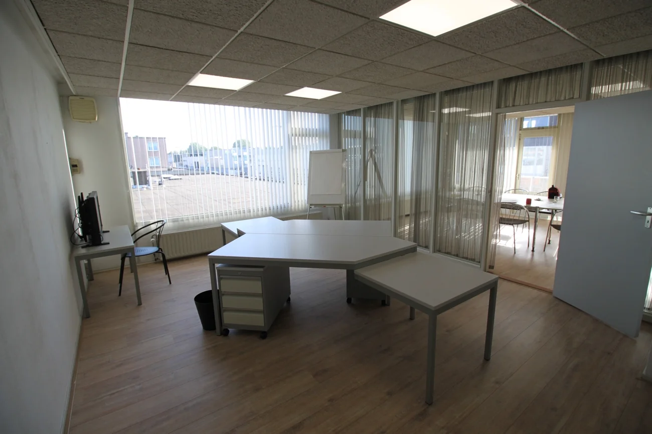 Kantoorruimte aan de Nevadadreef met modern bureau, groot raam en een whiteboard.