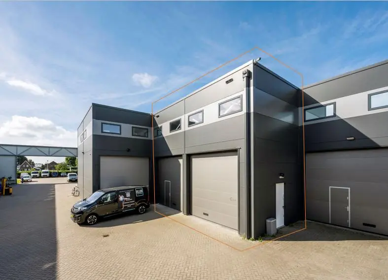 Moderne bedrijfspanden aan de Aalsmeerderweg met grijze gevels en grote overheaddeuren.
