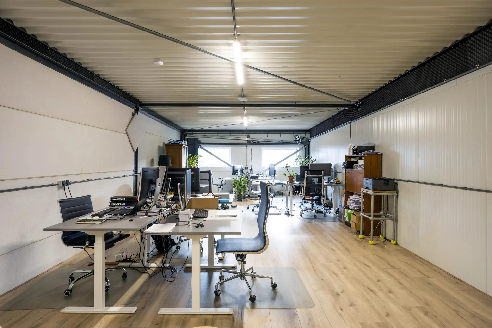 Modern ingericht kantoor met meerdere bureaus, kantoorstoelen en computers aan de Aalsmeerderweg.