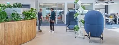 Moderne kantoorruimte aan de Ptolemaeuslaan met planten, zitpods en open werkplekken.