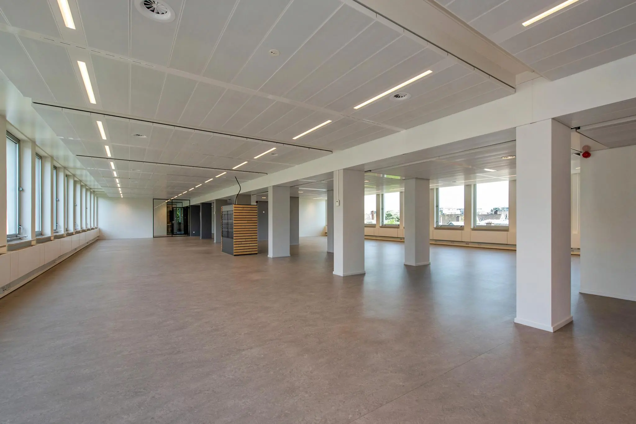 Licht en ruim leeg kantoorpand aan de Bezuidenhoutseweg met grote ramen en moderne afwerking.