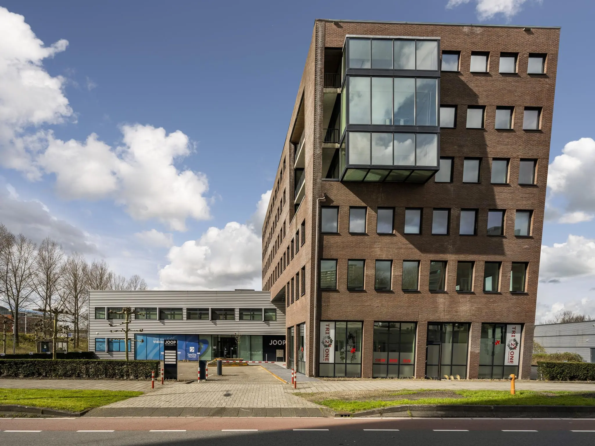 Kantoorgebouw aan de Joop Geesinkweg in Amsterdam met moderne architectuur en grote ramen.