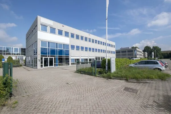 Moderne kantoorgebouw aan de Witboom met glazen gevel en parkeerplaats op de voorgrond.