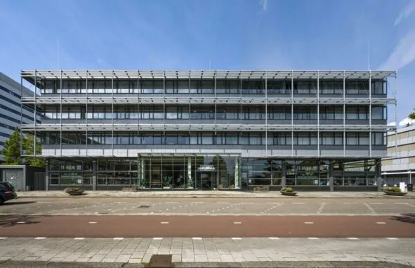 Vooraanzicht van een modern kantoorgebouw aan de Kabelweg in Amsterdam met glazen entree en verhuurborden.