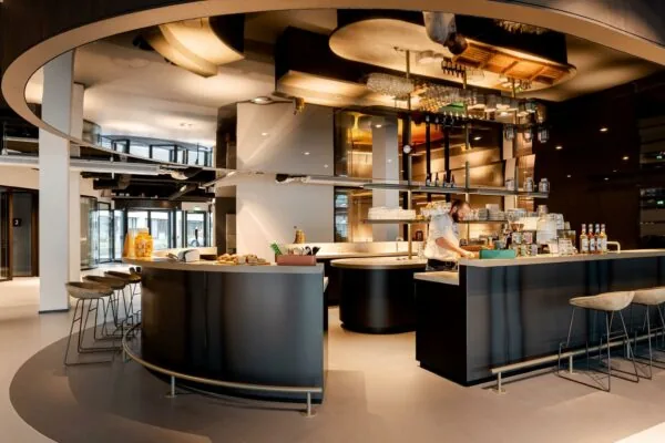 Moderne koffiebar met ronde balie en barista in een stijlvol interieur aan het Weena.