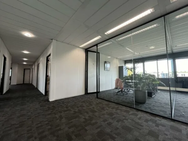 Moderne kantoorruimte aan de Wattbaan met glazen vergaderruimte en uitzicht op buiten.