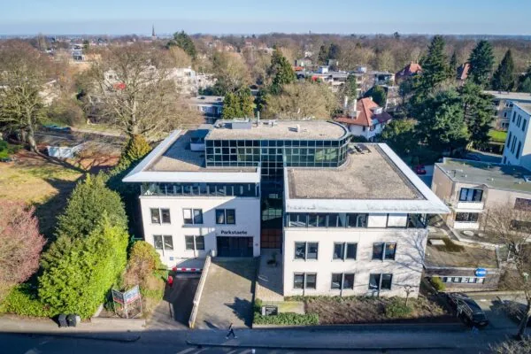 Luchtfoto van het kantoorgebouw Parkstaete aan de Amaliastraat, omringd door bomen en andere gebouwen.