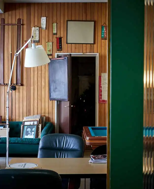 Interieur van een nostalgische ruimte aan de Ruysdaelkade met houten wandpanelen, vintage meubels en decoraties.