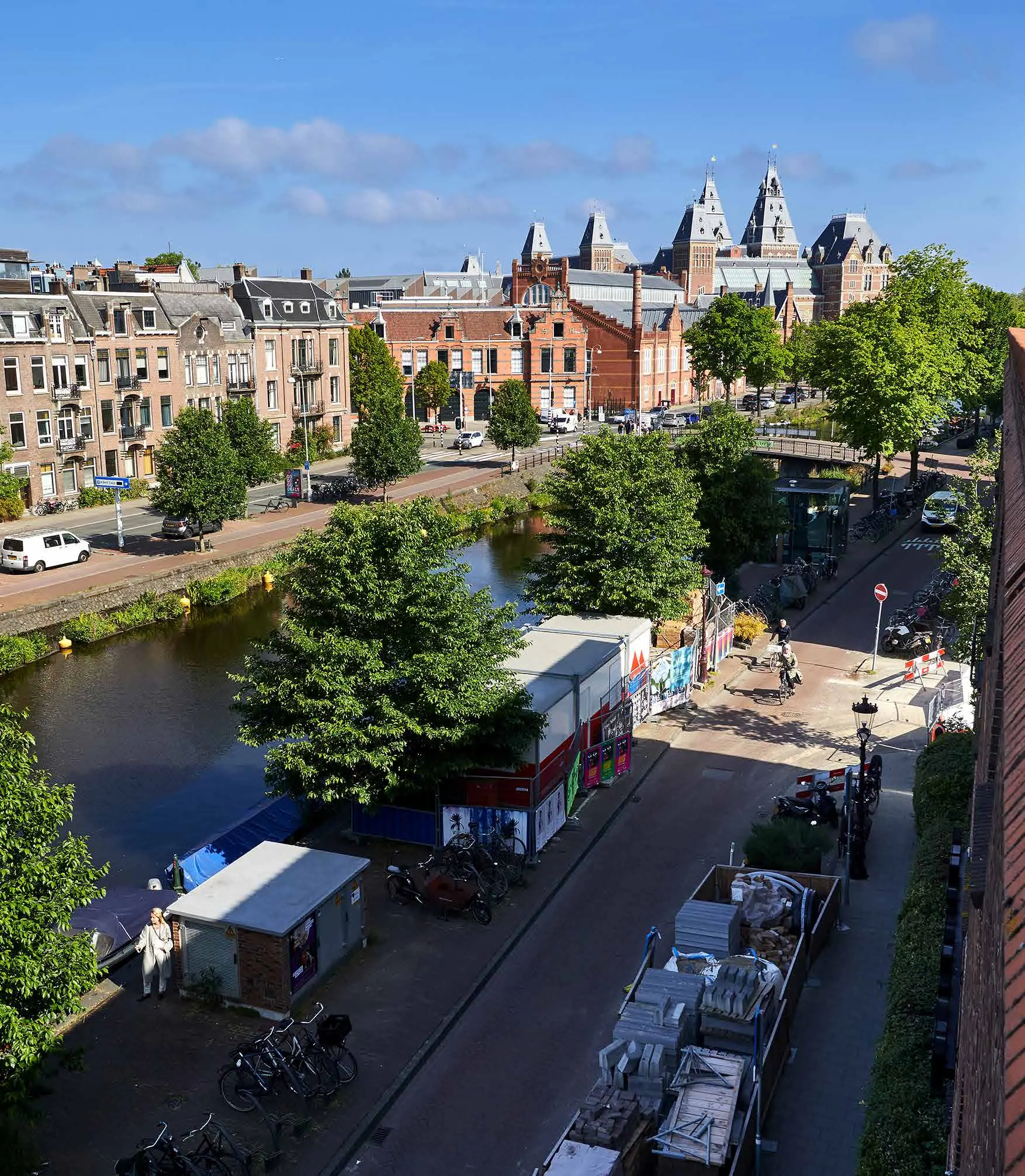 Uitzicht op de Ruysdaelkade in Amsterdam met het Rijksmuseum op de achtergrond en een gracht langs de straat.