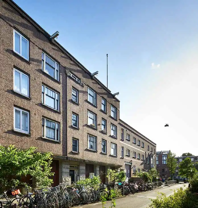 Appartementencomplex aan de Ruysdaelkade in Amsterdam met fietsen geparkeerd langs de stoep op een zonnige dag.