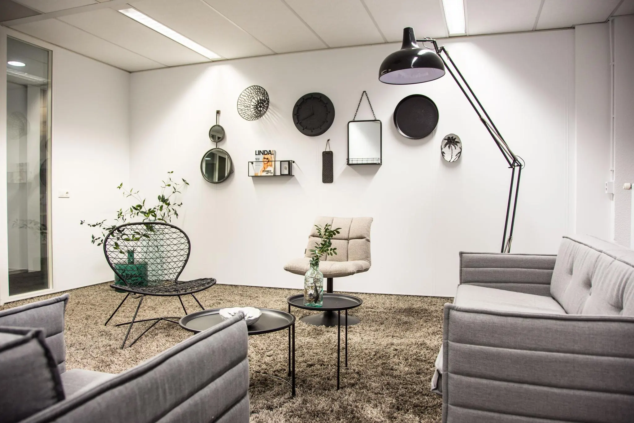 Moderne wachtruimte aan de Meidoornkade met strakke meubels, muurdecoratie en warme verlichting.