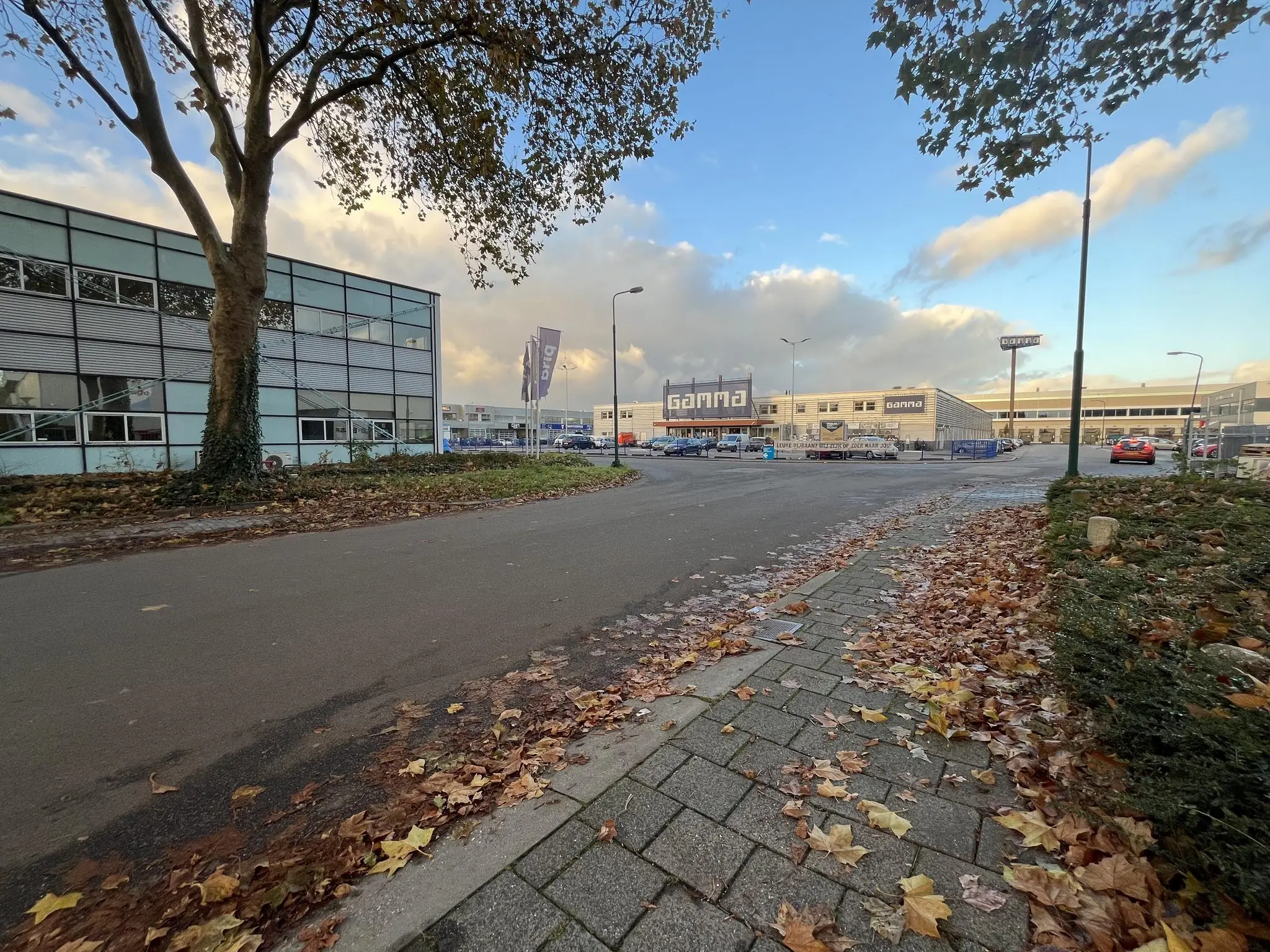 Zicht op de parkeerplaats en het gebouw van bouwmarkt Gamma aan de Industrieweg op een herfstdag.