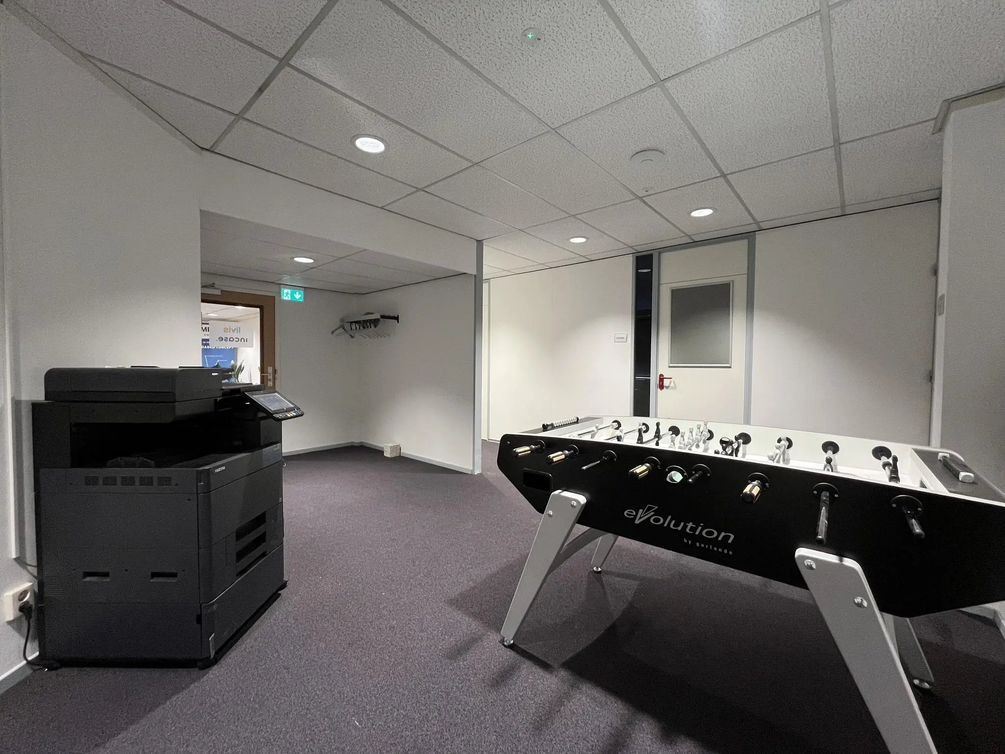 Kantoorruimte aan de Industrieweg met een voetbaltafel en een groot kopieerapparaat.