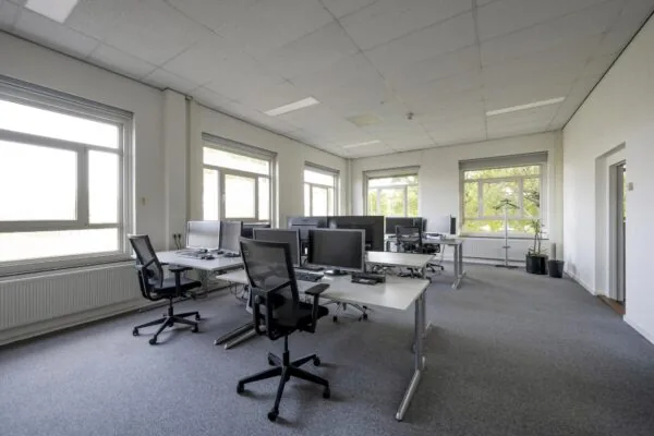 Modern en licht kantoor aan de Van der Madeweg met meerdere werkplekken en grote ramen.
