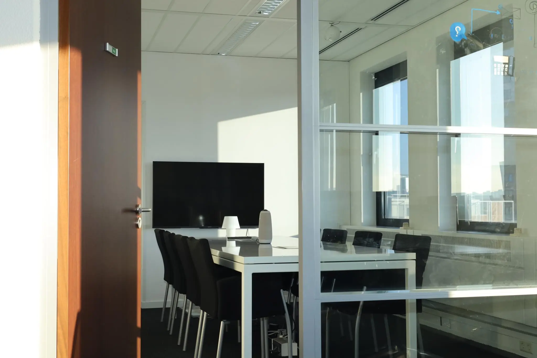 Vergaderruimte Radarweg met een lange tafel, zwarte stoelen en een groot scherm aan de muur.