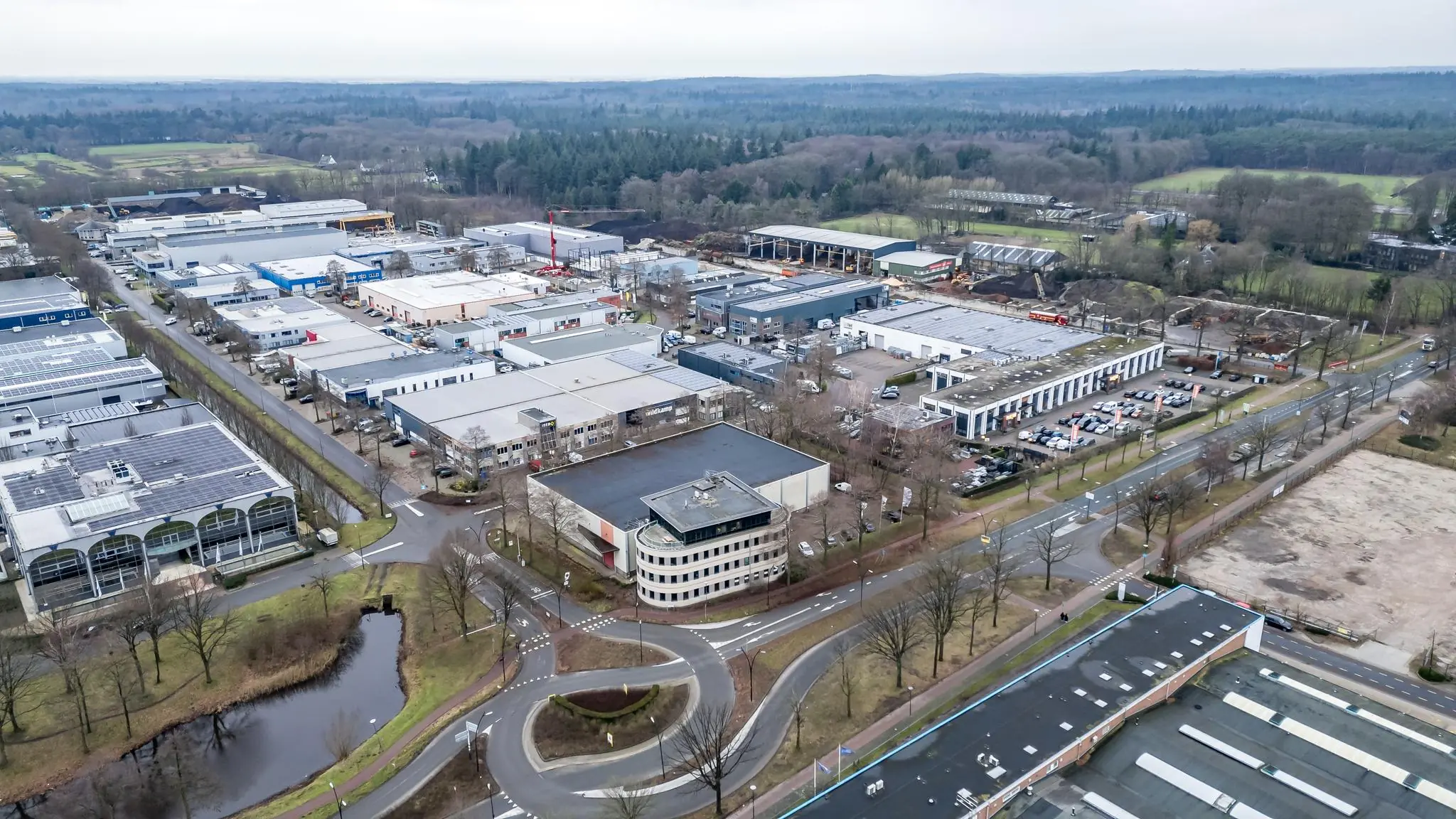 Luchtfoto van het industrieterrein Koningsweg met bedrijfsgebouwen, parkeerplaatsen en omliggend groen.