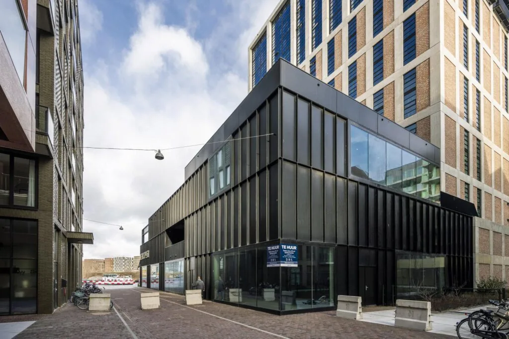 Moderne zwarte bedrijfsruimte te huur aan de Pieter Goosstraat, omgeven door hoge woongebouwen.