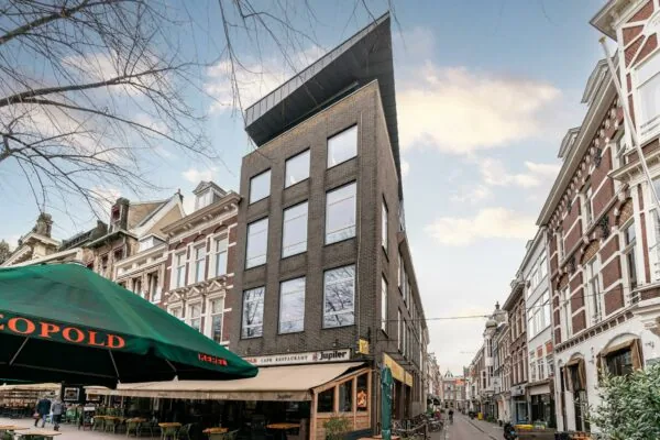 Straatbeeld van het Plein in Den Haag met café-restaurant Leopold en omliggende historische en moderne gevels.