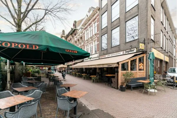 Terras en gevel van café-restaurant Leopold aan een gezellig plein met meerdere horecazaken.