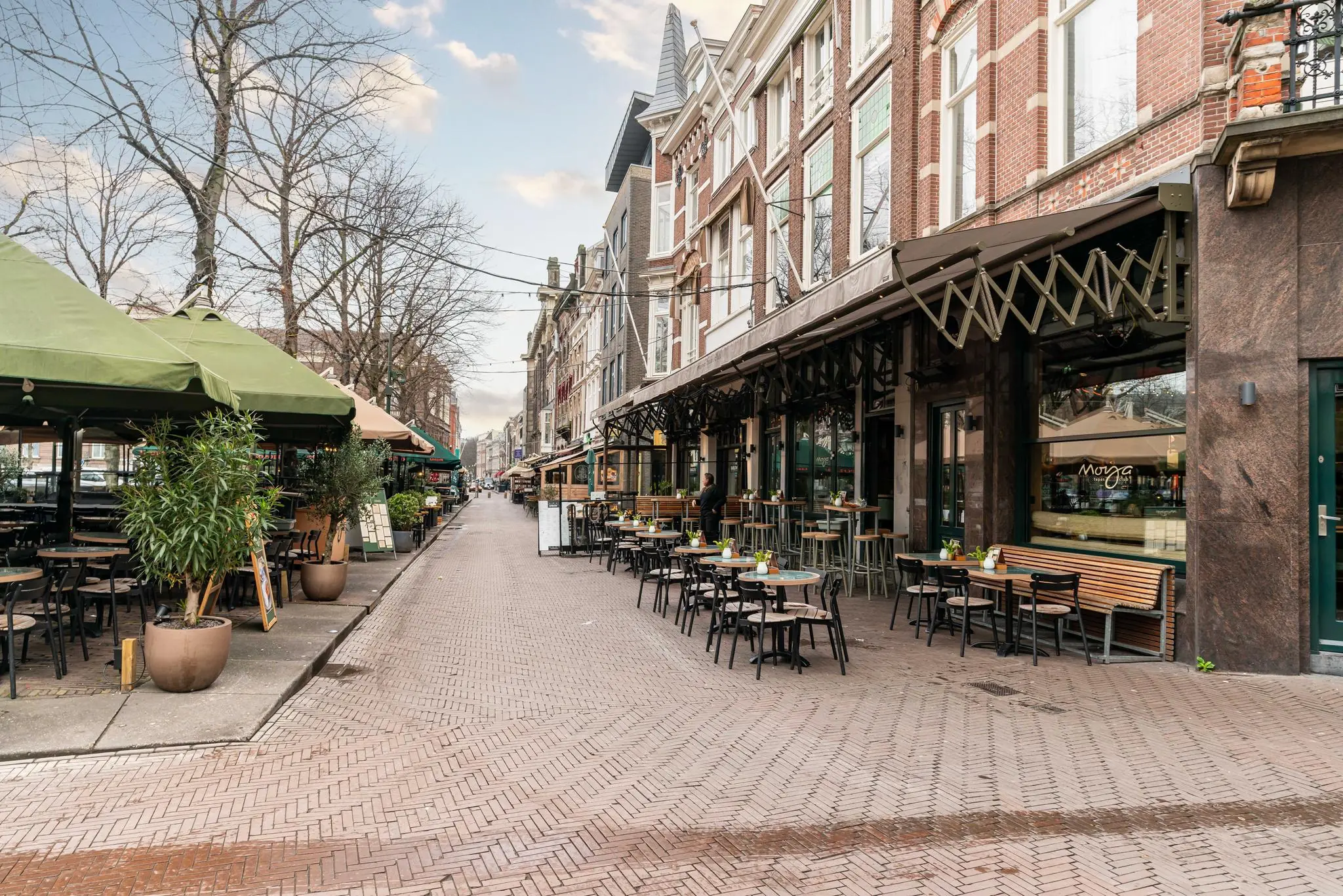 Een gezellig autovrij plein met terrassen en restaurants in een historische straat, waarschijnlijk genaamd Plein.