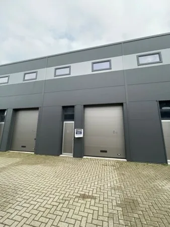 Grijs bedrijfsunit aan de Aalsmeerderweg met te huur-bord bij deur D.07.