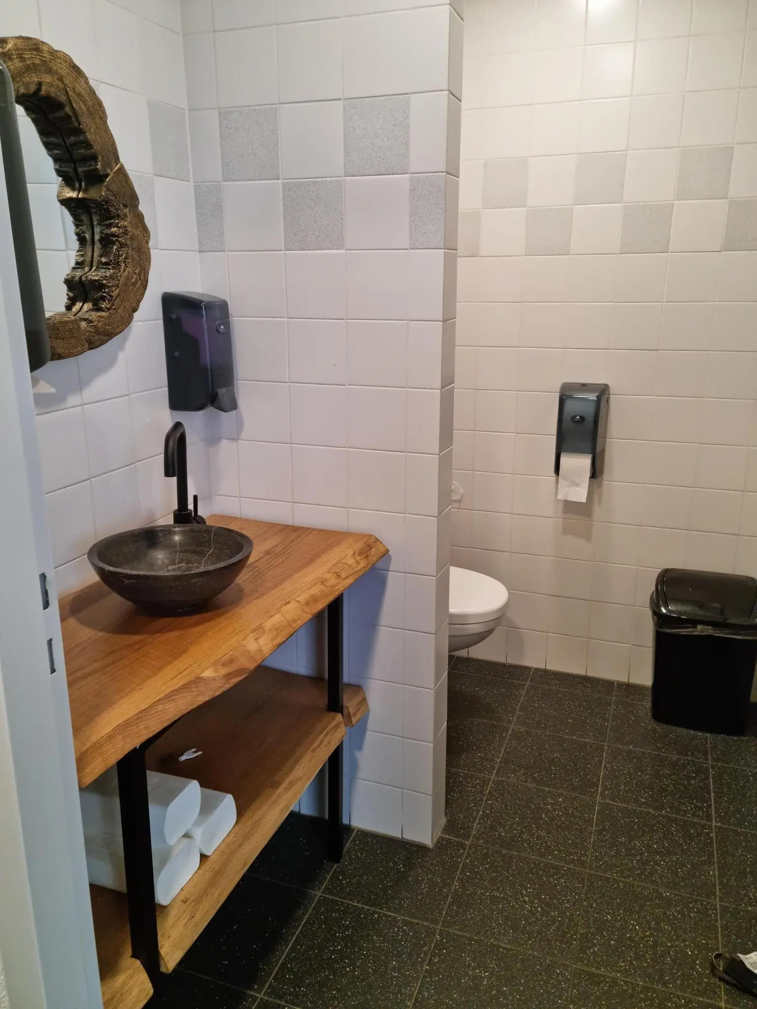 Moderne toiletruimte aan de Frankfurtstraat met een houten wastafelmeubel, stenen waskom en hangtoilet.
