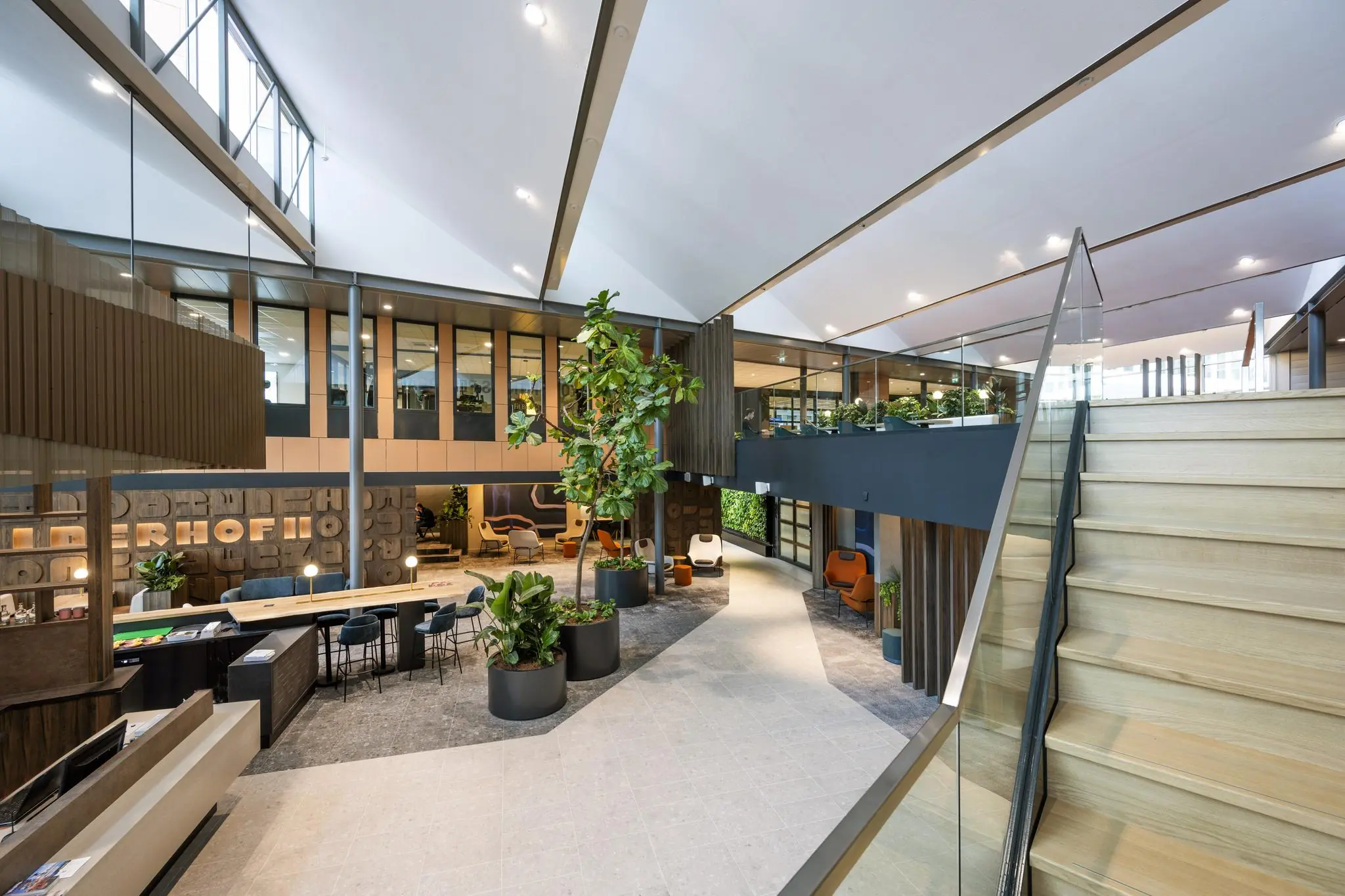 Moderne en sfeervolle kantoorlobby aan de Jachthavenweg met veel natuurlijk licht, planten en zithoeken.