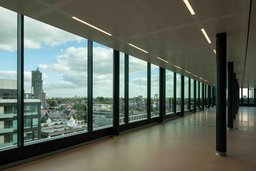 Uitzicht vanuit een modern kantoorgebouw aan de Catharijnesingel over de stad Utrecht met grote ramen en skyline op de achtergrond.