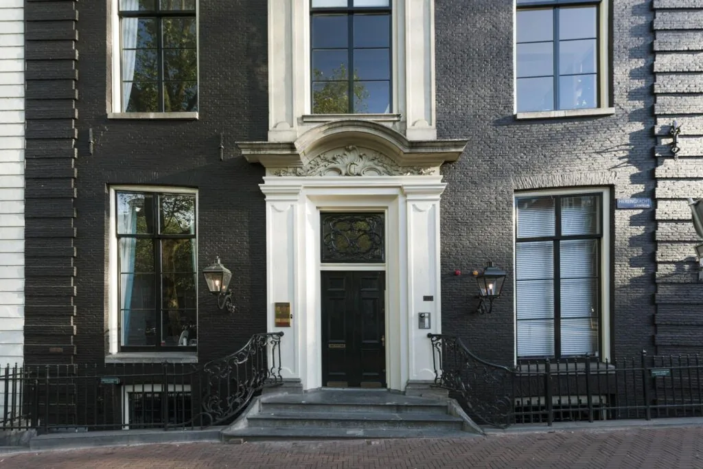 Voordeur en gevel van een statig grachtenpand aan de Herengracht in Amsterdam.