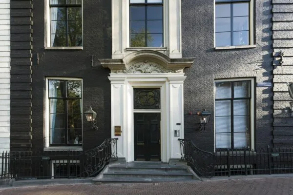 Voordeur en gevel van een statig grachtenpand aan de Herengracht in Amsterdam.