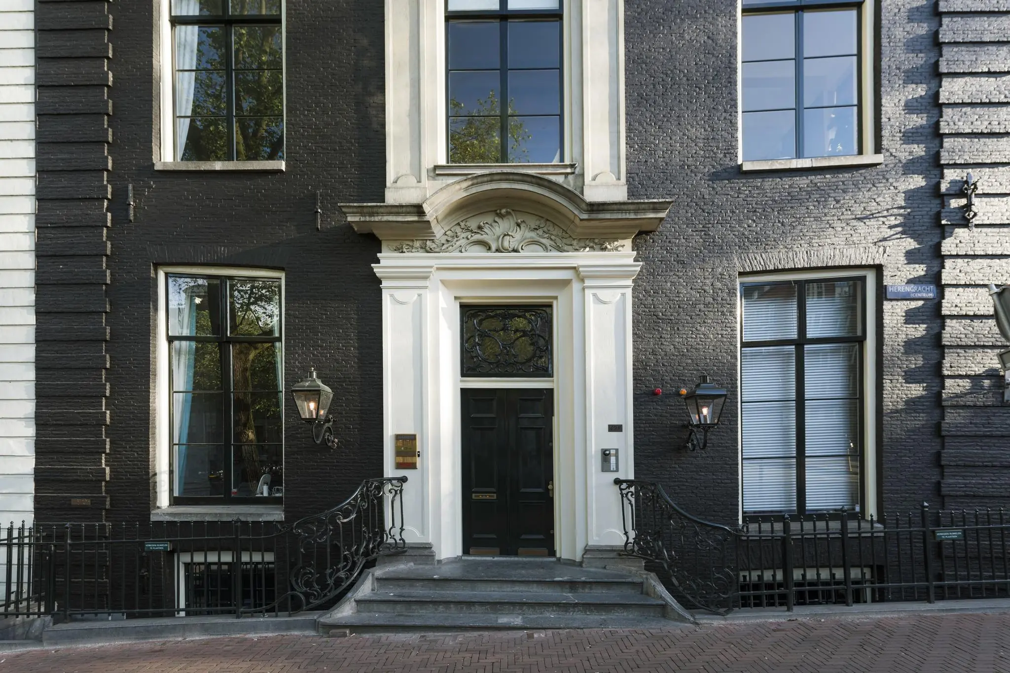 Voordeur en gevel van een statig grachtenpand aan de Herengracht in Amsterdam.